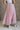 Back view of female model wearing the Adele Dusty Pink Pleated Tulle Midi Skirt which features Dusty Pink Tulle Pleated Fabric, Dusty Pink Lining, Midi Length and Satin Elastic Band