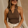 Front view of female model wearing the Maisie Ribbed Collar Tank in brown that feature brown ribbed fabric and a collared sleeveless neckline. Paired with white shotrs