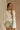 Front view of female model wearing the Kimberly Cream Pleated Long Sleeve Top which features Cream Sheer Plisse Fabric, Cropped Waist, Lettuce Hem Details, Round Neckline and Open Back with Tie Closures