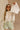 Front view of female model wearing the Kimberly Cream Pleated Long Sleeve Top which features Cream Sheer Plisse Fabric, Cropped Waist, Lettuce Hem Details, Round Neckline and Open Back with Tie Closures