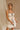 Front view of model wearing the Rosalind Cream & Black Sheer Mini Skirt, which has lined cream sheer fabric, black ruffle and tie details, and an elastic waist. Paired with matching top.