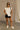Full body view of female model wearing the Ava Washed Black Denim Shorts which features Washed Black Denim Fabric, Two Front Pockets, Two Back Pockets, Silver Button with Zipper Closure and Belt Loops