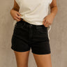 Front view of female model wearing the Ava Washed Black Denim Shorts which features Washed Black Denim Fabric, Two Front Pockets, Two Back Pockets, Silver Button with Zipper Closure and Belt Loops