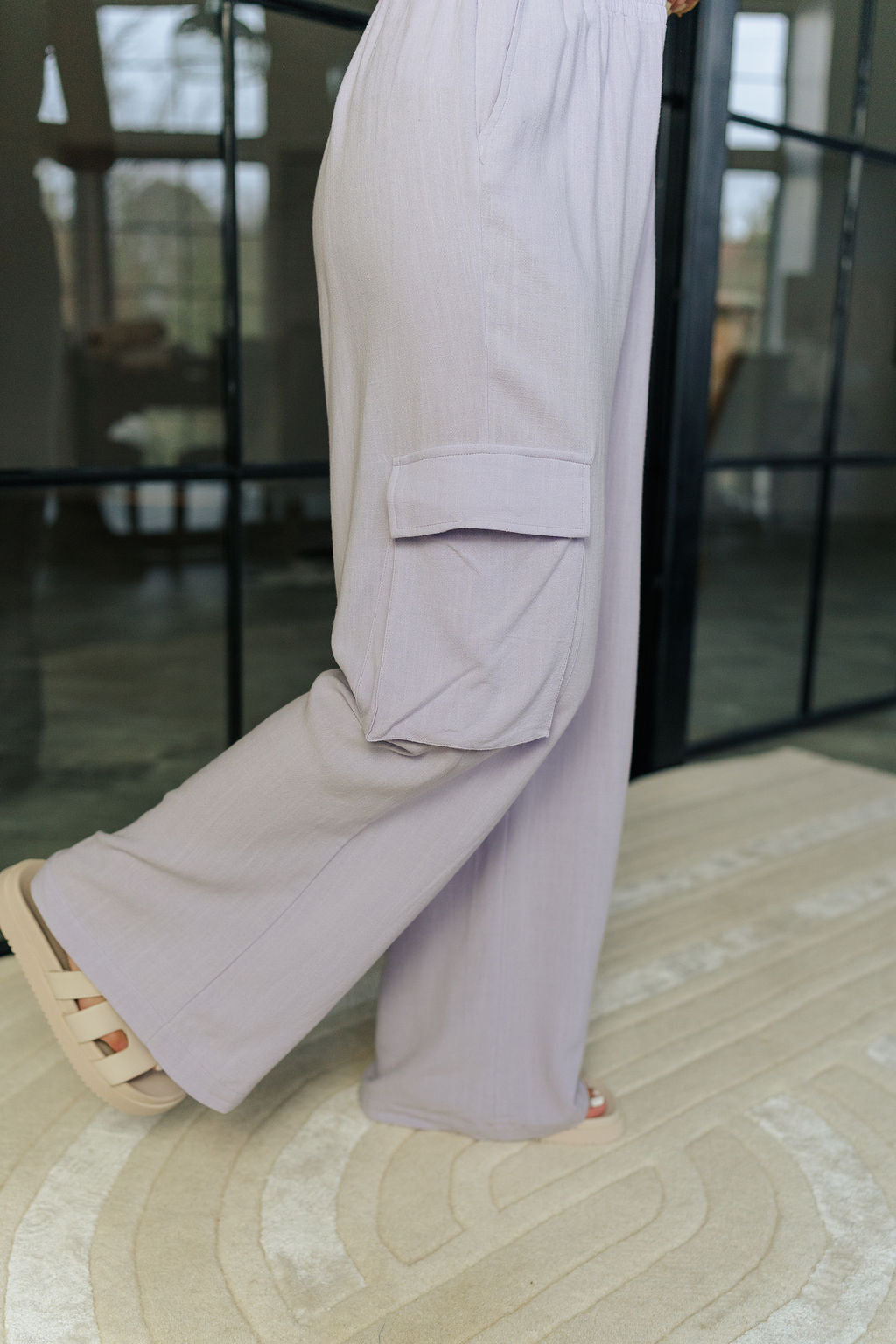 Side view of female model wearing the Mila Lavender Cargo Pants which features Lavender Lightweight Fabric, Two Side Cargo Pockets, Two Front Pockets and Elastic Waistband.