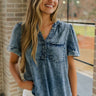 Front view of female model wearing the Tarah Medium Wash Short Sleeve Top which features washed denim tencel fabric, scooped hem, front left chest pocket, monochrome quarter button up, v-neckline and short sleeves