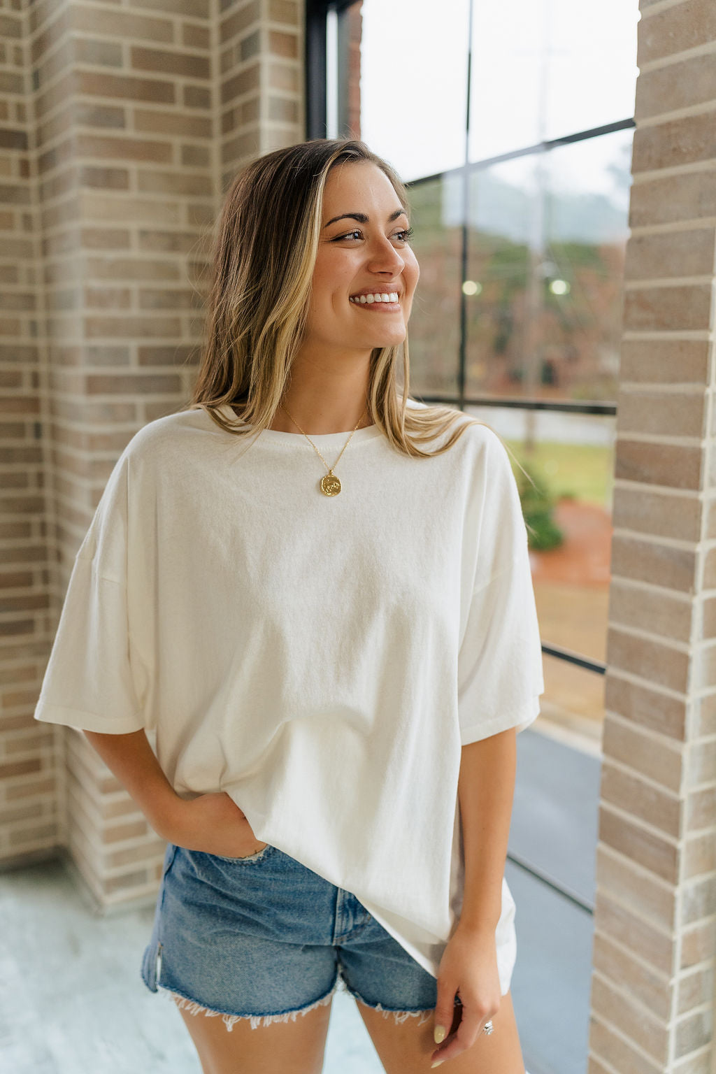 Front view of female model wearing the Melissa Off White Short Sleeve Top which features Off White Cotton Fabric, Round Neckline and Short Sleeves