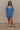 Front view of model wearing the Marissa Blue and White Floral Short Sleeve Romper which features Blue Lightweight Fabric, White Floral Design, Blue Lining, Square Neckline, Short Puff Sleeves and Smocked Back.