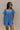 Front view of model wearing the Marissa Blue and White Floral Short Sleeve Romper which features Blue Lightweight Fabric, White Floral Design, Blue Lining, Square Neckline, Short Puff Sleeves and Smocked Back.