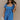 Front view of model wearing the Marissa Blue and White Floral Short Sleeve Romper which features Blue Lightweight Fabric, White Floral Design, Blue Lining, Square Neckline, Short Puff Sleeves and Smocked Back.