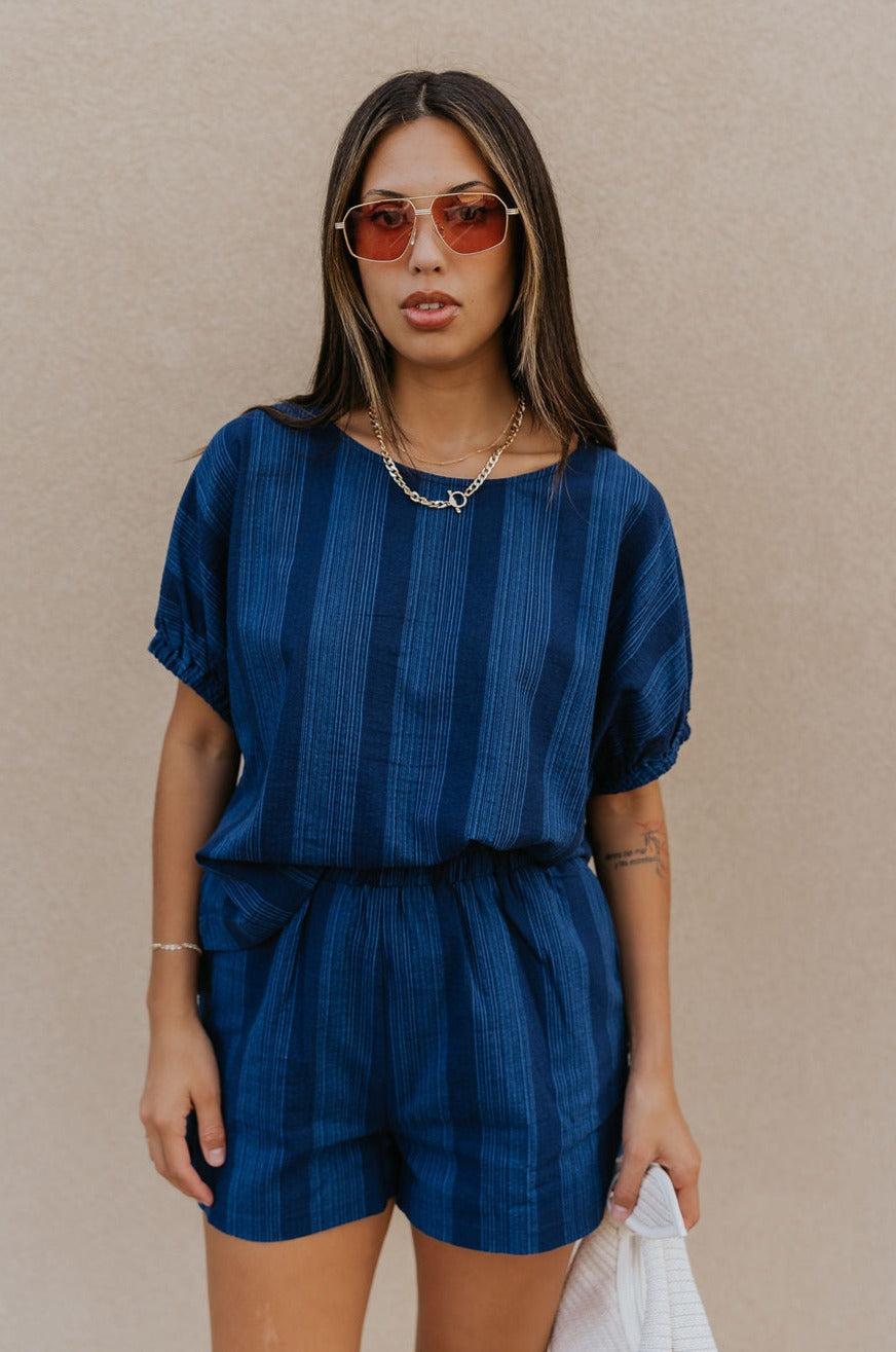 Front view of female model wearing the Julissa Navy Stripe Short Sleeve Top which features Navy Blue with Light Blue Stripe Design, Round Neckline and Short Sleeves