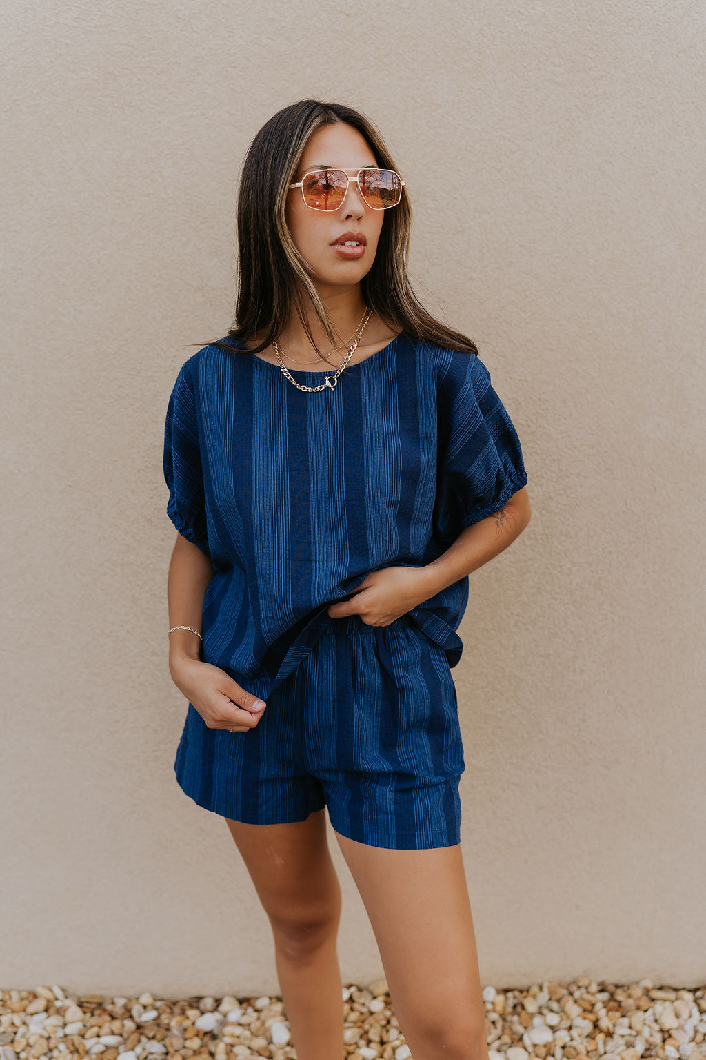 Front view of female model wearing the Julissa Navy Stripe Shorts which features Navy Blue with Light Blue Stripe Design, Elastic Waistband, Two Front Pockets and Two Back Pockets.