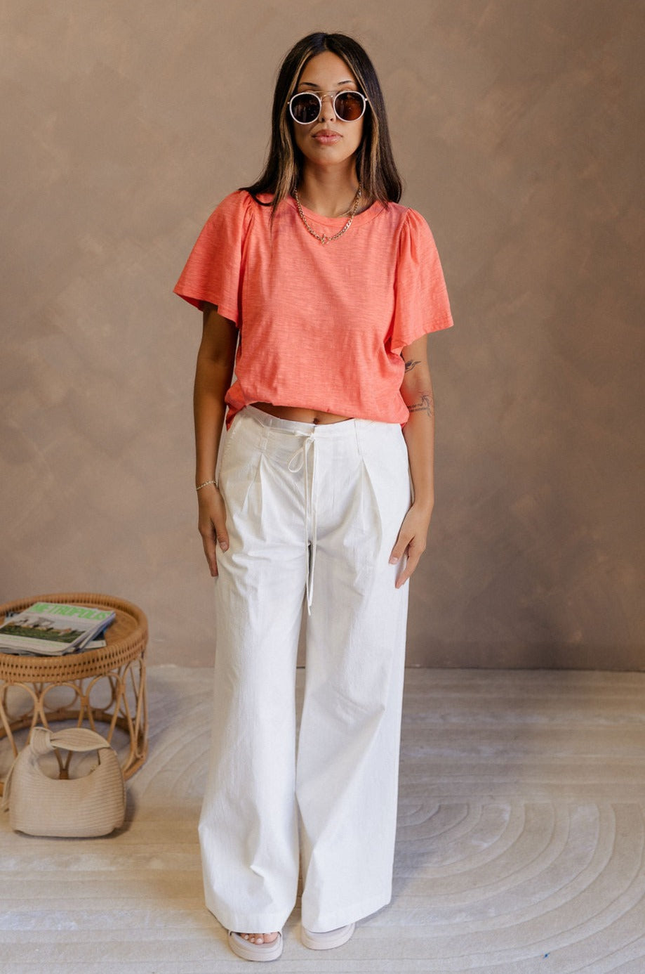 Full body view of female model wearing the Harper Coral Short Sleeve Top which features Coral Cotton Fabric, Round Neckline and Short Sleeves.