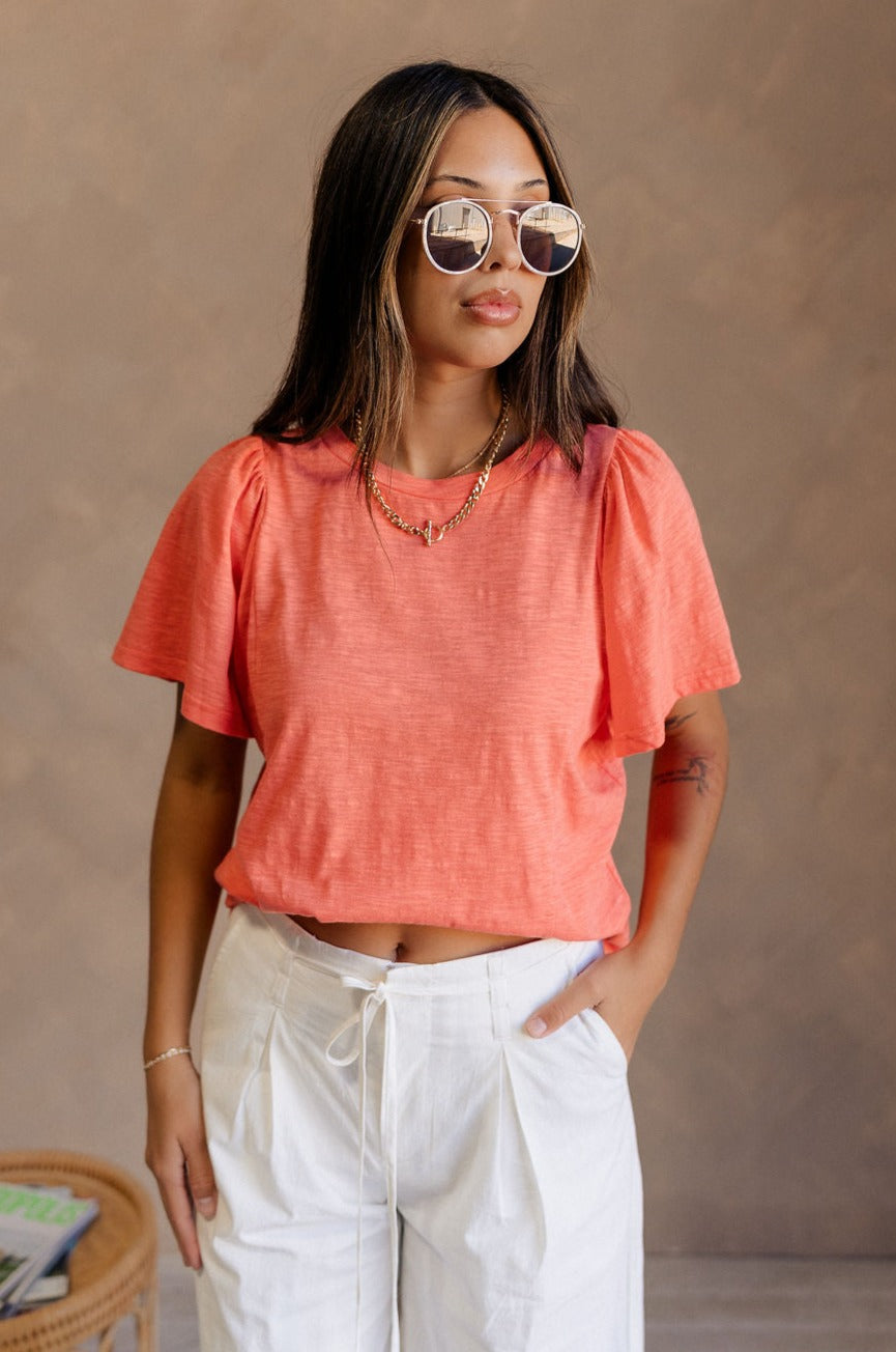 Front view of female model wearing the Harper Coral Short Sleeve Top which features Coral Cotton Fabric, Round Neckline and Short Sleeves.
