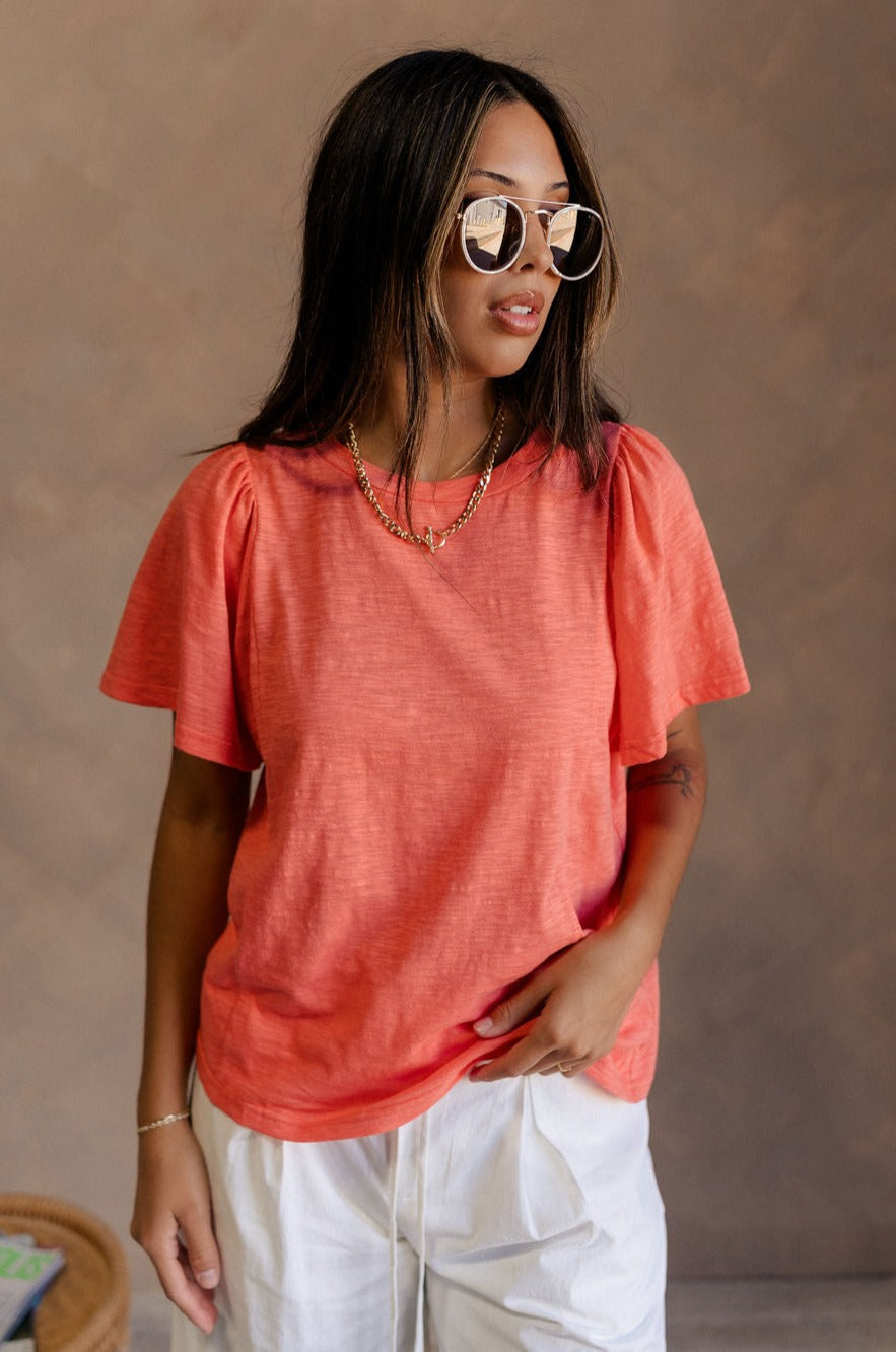 Front view of female model wearing the Harper Coral Short Sleeve Top which features Coral Cotton Fabric, Round Neckline and Short Sleeves.
