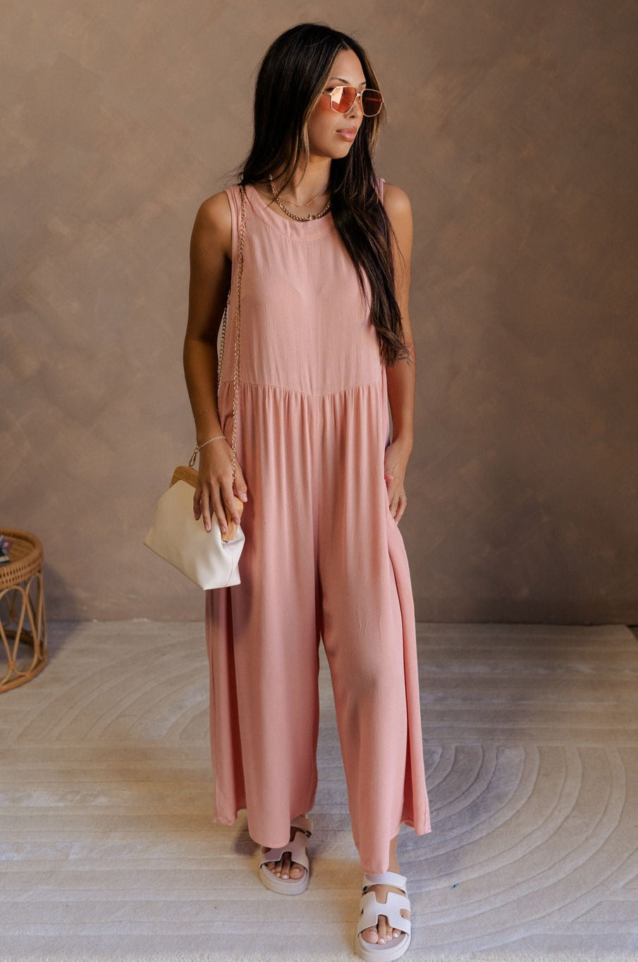 Full body view of female model wearing the Brooklyn Sleeveless Wide Leg Jumpsuit in salmon pink which features Wide Pant Legs, Two Front Pockets, Lined Pant Legs, Round Neckline and Sleeveless.