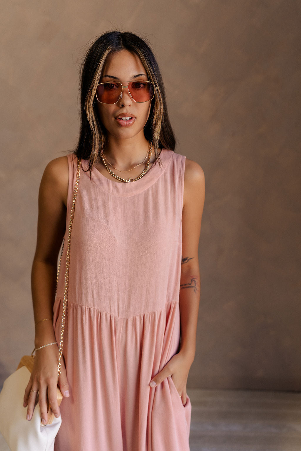 Front view of female model wearing the Brooklyn Sleeveless Wide Leg Jumpsuit in salmon pink which features Wide Pant Legs, Two Front Pockets, Lined Pant Legs, Round Neckline and Sleeveless.