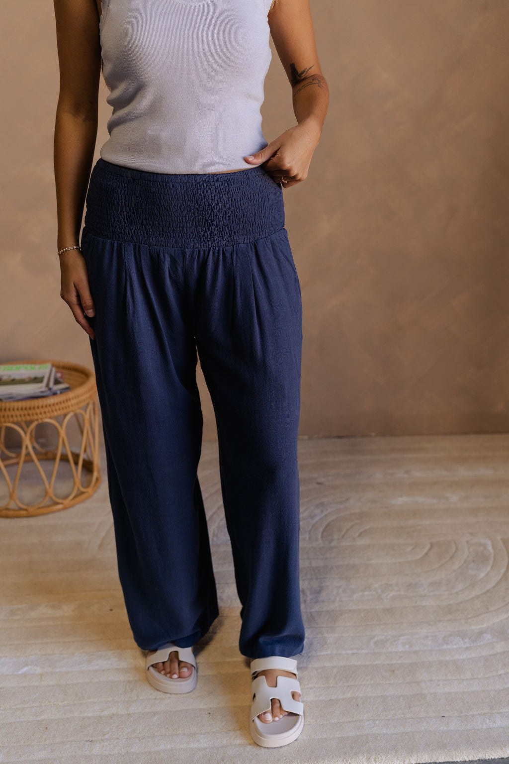 Front view of female model wearing the Olivia Navy Blue Smocked Pants which features Navy Knit Fabric, Wide Pant Legs, Navy Lining and Smocked Waistband