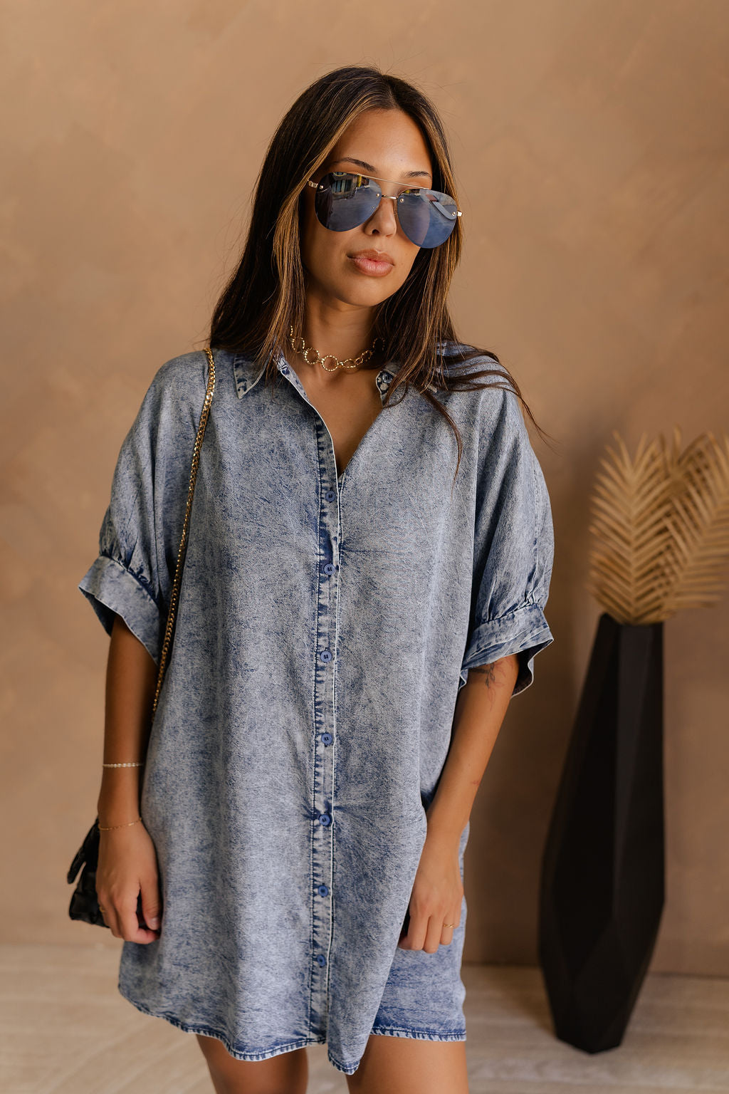 Front view of female model wearing the Emma Button-Up Short Sleeve Mini Dress in Washed Denim which features Tencel Fabric, Mini Length, Front Button-Up Closure, Collared Neckline and Short Puff Sleeves.