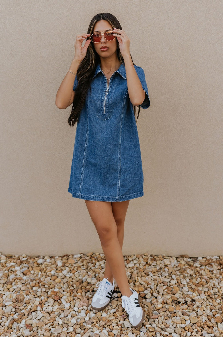 Full body front view of model wearing the Jada Denim Short Sleeve Mini Dress that has dark wash denim fabric, a zippered neckline with a collar, and short sleeves.