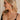Side view of female model wearing the Delilah Pearl Hoop Earring which features oversized pearl beads with gold details and large open hoops with back closure