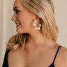 Side view of female model wearing the Delilah Pearl Hoop Earring which features oversized pearl beads with gold details and large open hoops with back closure
