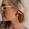 Side view of female model wearing the Alexis Gold Ribbed Scooped Stud Earring which features  gold ribbed scoop shaped studs with back clasp closure