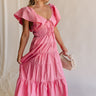 Full body view of female model wearing the Gianna Ruffle Short Sleeve Tiered Maxi Dress in PInk which features Lightweight Fabric, Tiered Body, Midi Length, Pockets on each side, V-Neckline with a Tie Detail and Ruffle Short Sleeves. the dress is available in pink, aqua blue and white.