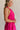 Side view of female model wearing the Luna Halter Tie Tiered Maxi Dress in Pink which features Lightweight Fabric, Tiered Body, Maxi Length, Thigh Length Lining, Halter Neckline with Tie and Open Back