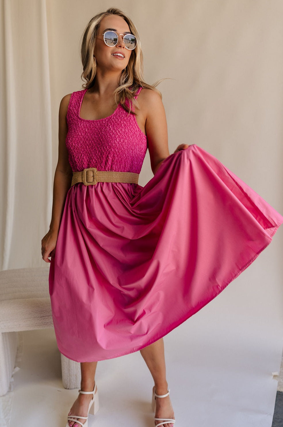Full body view of female model wearing the Cecilia Pink Smocked Midi Dress which features Pink Lightweight Fabric, Pink Lining, Pockets On Each Side, Midi Length, Textured Upper, Square Neckline and Sleeveless