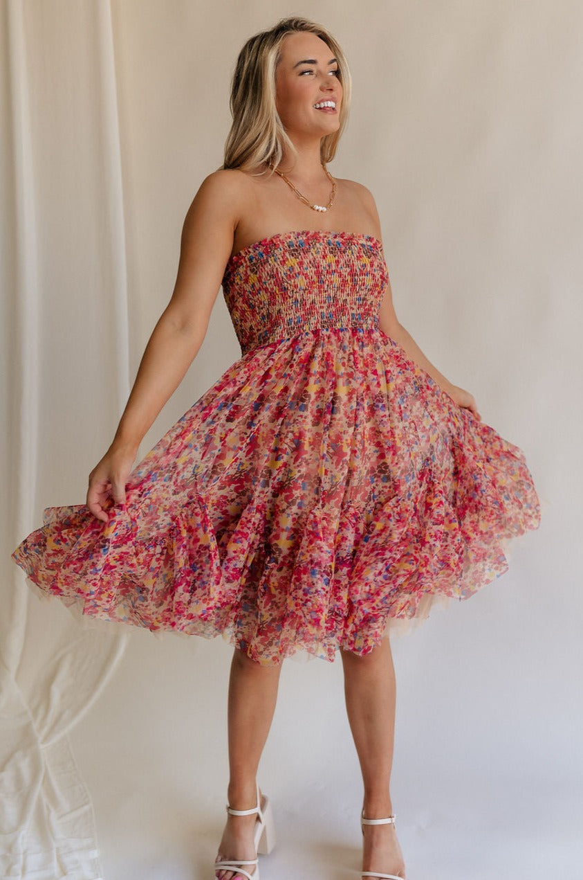 Full body view of female model wearing the Charlie Pink Multi Floral Flare Mini Dress which features Brown, Pink, Yellow, Blue and Tan Sheer Fabric, Floral Print, Ruffle Hem, Tan Lining, Midi Length and Smocked Upper