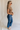 Full body side view of female model wearing the Emerson Medium Wash Straight Leg Jeans which features Medium Wash Denim, Two Front Pockets, Two Back Pockets, Front Zipper with Button Closure, Belt Loops and Straight Pant Legs