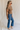 Full body side view of female model wearing the Emerson Medium Wash Straight Leg Jeans which features Medium Wash Denim, Two Front Pockets, Two Back Pockets, Front Zipper with Button Closure, Belt Loops and Straight Pant Legs
