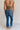 Back view of female model wearing the Emerson Medium Wash Straight Leg Jeans which features Medium Wash Denim, Two Front Pockets, Two Back Pockets, Front Zipper with Button Closure, Belt Loops and Straight Pant Legs