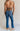 Back view of female model wearing the Emerson Medium Wash Straight Leg Jeans which features Medium Wash Denim, Two Front Pockets, Two Back Pockets, Front Zipper with Button Closure, Belt Loops and Straight Pant Legs