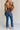 Back view of female model wearing the Emerson Medium Wash Straight Leg Jeans which features Medium Wash Denim, Two Front Pockets, Two Back Pockets, Front Zipper with Button Closure, Belt Loops and Straight Pant Legs