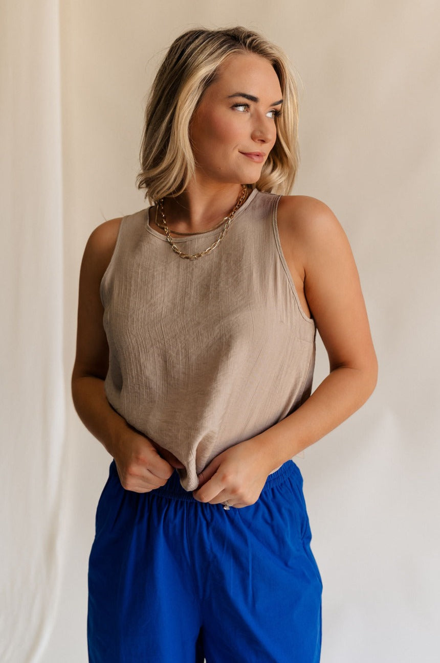 Front view of female model wearing the Sienna Light Taupe Sleeveless Tank which features Lightweight Taupe Fabric, Round Neckline, Sleeveless and Back Key Hole with Button Closure 