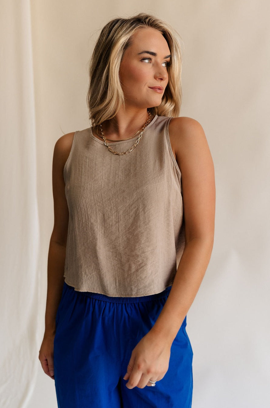 Front view of female model wearing the Sienna Light Taupe Sleeveless Tank which features Lightweight Taupe Fabric, Round Neckline, Sleeveless and Back Key Hole with Button Closure