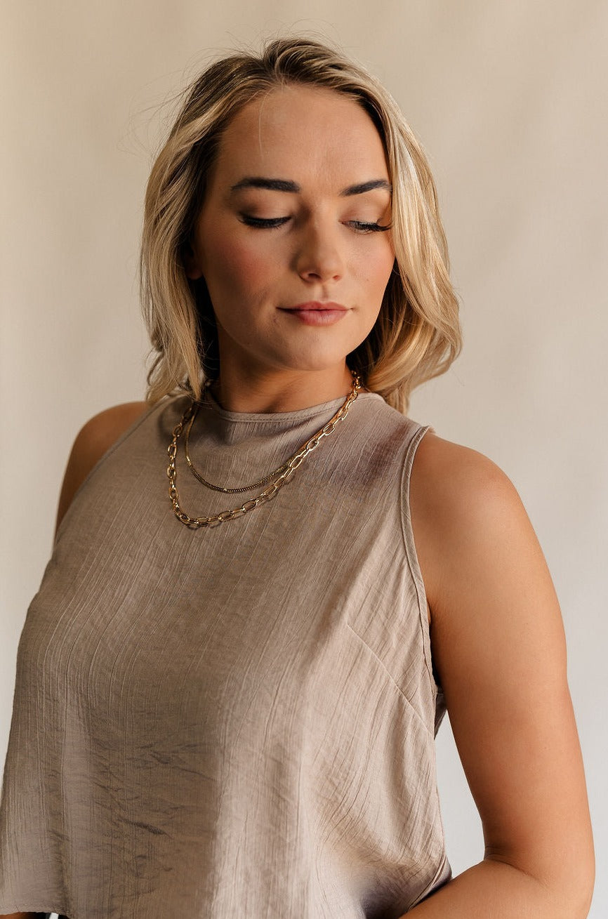 Front view of female model wearing the Annalise Gold Chain Layered Necklace which features one flat gold layer, gold chain layer and adjustable clasp closure