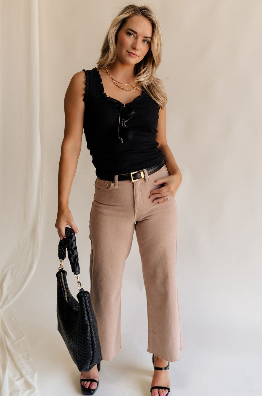 Full body view of female model wearing the Lena Light Taupe Wide Cropped Leg Pants which features Light Taupe Denim Fabric, Wide Pant Leg, Raw Hem, Front Zipper with Button Closure, Two Front Pockets, Two Back Pockets and Belt Loops