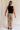 Full body back view of female model wearing the Lena Light Taupe Wide Cropped Leg Pants which features Light Taupe Denim Fabric, Wide Pant Leg, Raw Hem, Front Zipper with Button Closure, Two Front Pockets, Two Back Pockets and Belt Loops