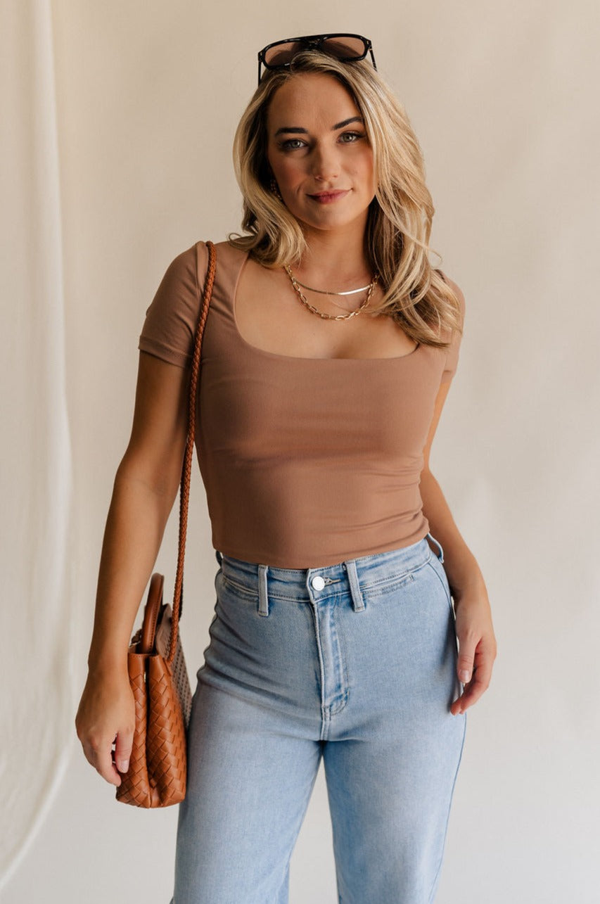 Front view of female model weariing the Saylor Toffee Brown Short Sleeve Top which features Light Brown Lightweight Fabric, Square Neckline and Short Sleeves