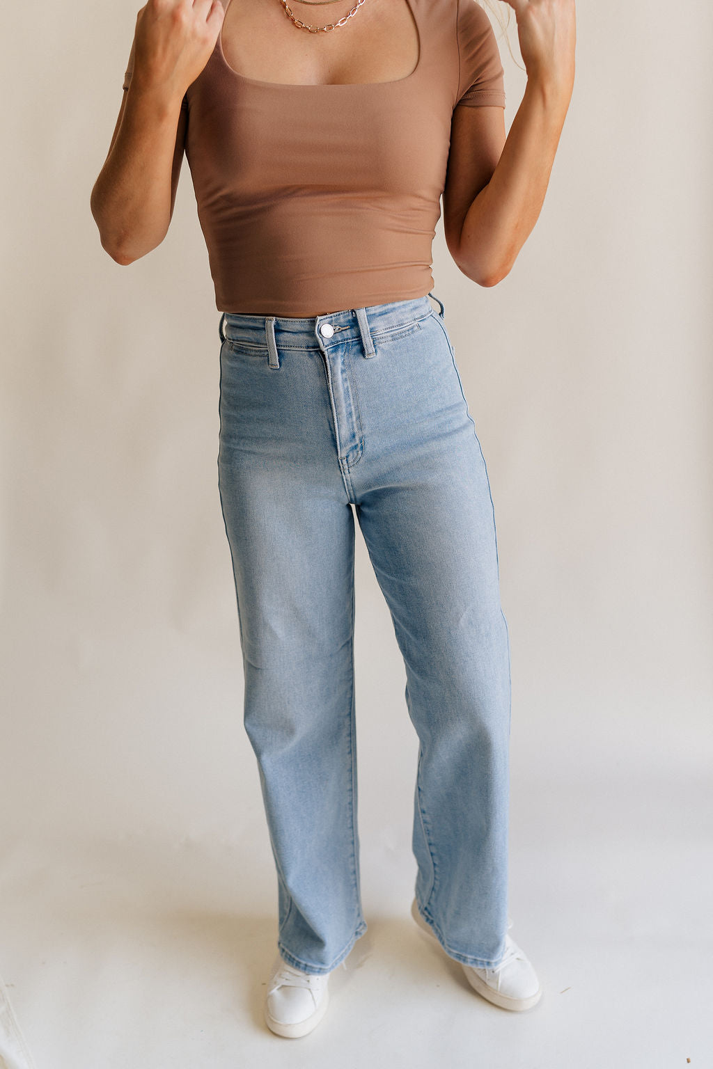 Front view of female model wearing the Stevie Light Denim Wash Wide Leg Jeans which features Light Denim Wash Fabric, Two Front Pockets, Two Back Pockets, Front Zipper with Button Closure, Belt Loops and Wide Pant Legs