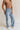 Frontal side view of female model wearing the Stevie Light Denim Wash Wide Leg Jeans which features Light Denim Wash Fabric, Two Front Pockets, Two Back Pockets, Front Zipper with Button Closure, Belt Loops and Wide Pant Legs