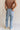 Back view of female model wearing the Stevie Light Denim Wash Wide Leg Jeans which features Light Denim Wash Fabric, Two Front Pockets, Two Back Pockets, Front Zipper with Button Closure, Belt Loops and Wide Pant Legs