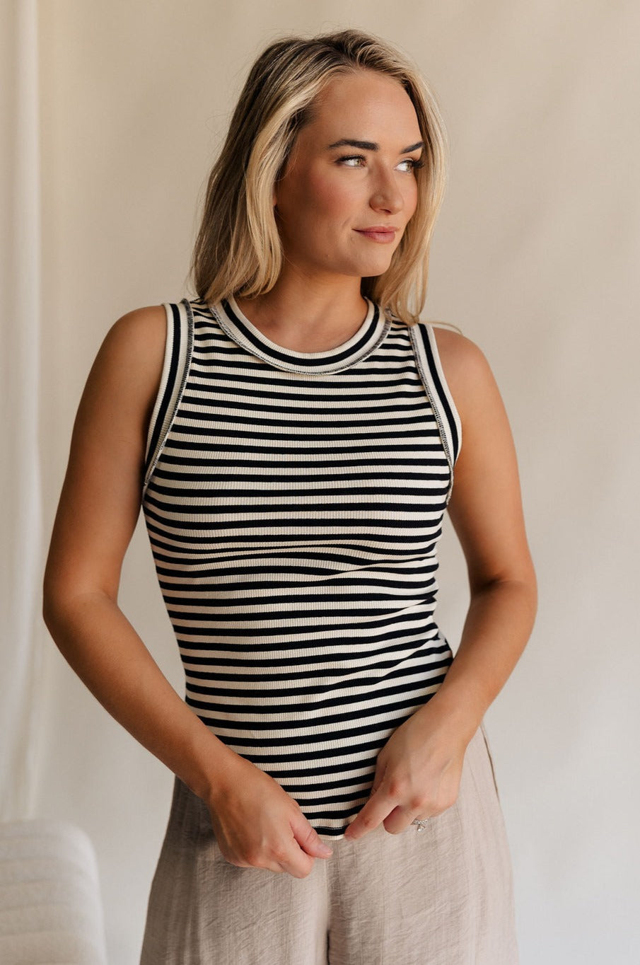 Front view of female model wearing the Lilah Black & Cream Stripe Sleeveless Tank which features  Black and Cream Knit Fabric, Stripe Pattern, Round Neckline and Sleeveless