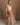 Full body front view of female model wearing the Bristol Mocha & Tan Maxi Dress that has a tan knit upper with thick straps, a mocha maxi skirt, and a drawstring waist. Worn with brown purse.
