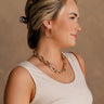 Side view of female model wearing the Simone Gold Chain Link Necklace which features shiny gold, chunky chain links linked together with an adjustable clasp closure.