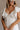 Close up front view of female model wearing the Gianna Ruffle Short Sleeve Tiered Maxi Dress in White which features Lightweight Fabric, Tiered Body, Midi Length, Pockets on each side, V-Neckline with a Tie Detail and Ruffle Short Sleeves. the dress is available in pink, aqua blue and white.