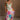 Full body front view of model wearing the Alia Pleated Floral Maxi Dress that has multi-colored fabric with a floral print, pleating, thin straps, and a sweetheart neck. Model is holding skirt.