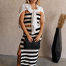 Full body front view of model wearing the Maxine Black & White Striped Midi Skirt that has horizontal black and white stripes and a side slit. Worn with matching top and sweater around shoulders.